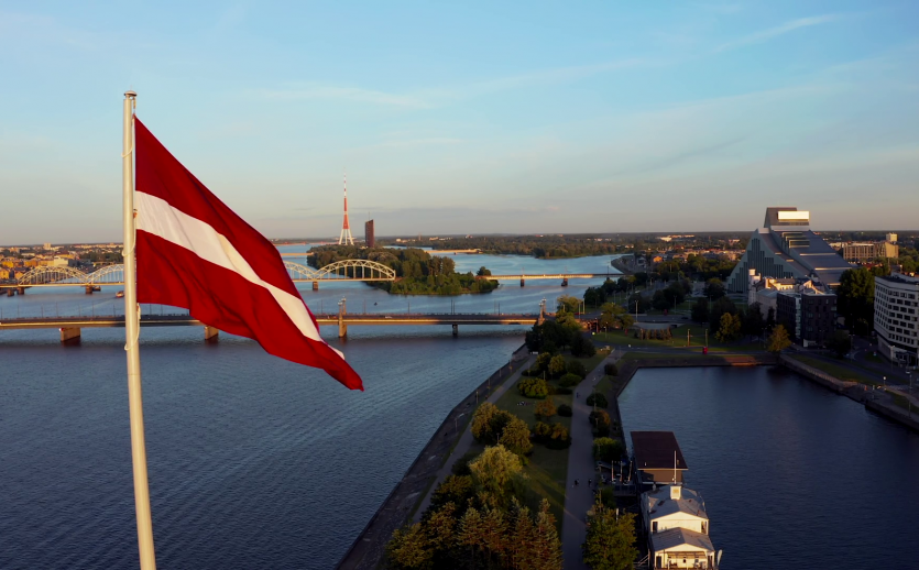 videoblocks-huge-latvian-flag-flutters-on-wind-with-riga-old-town-in-the-background-in-latvia-patriotic-video_holtc11xw_thumbnail-1080_01